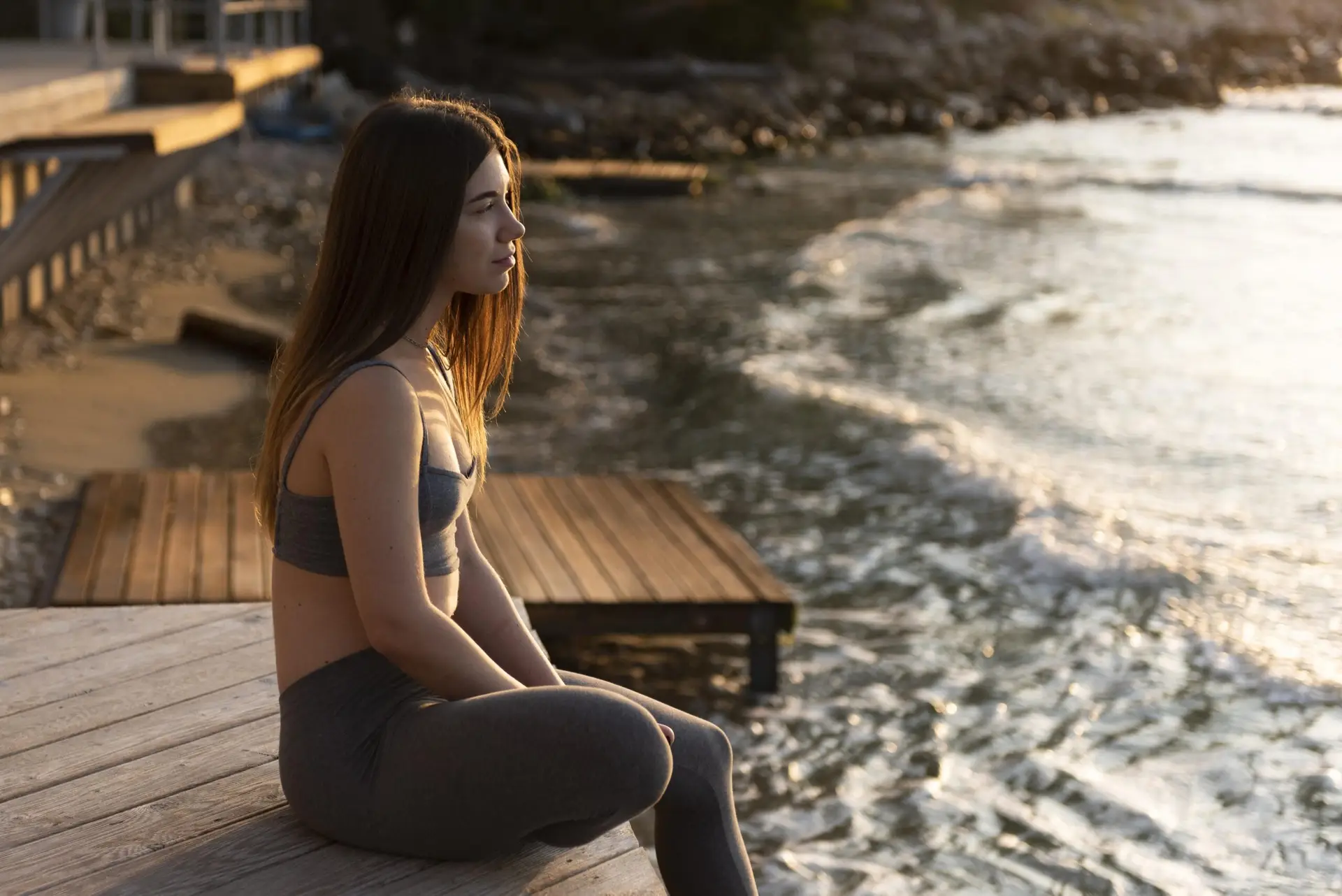 Person sitting calmly by the sea during addiction recovery at Holina Rehab
