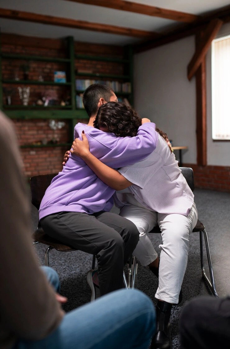 A group of people sitting together in a peer support meeting