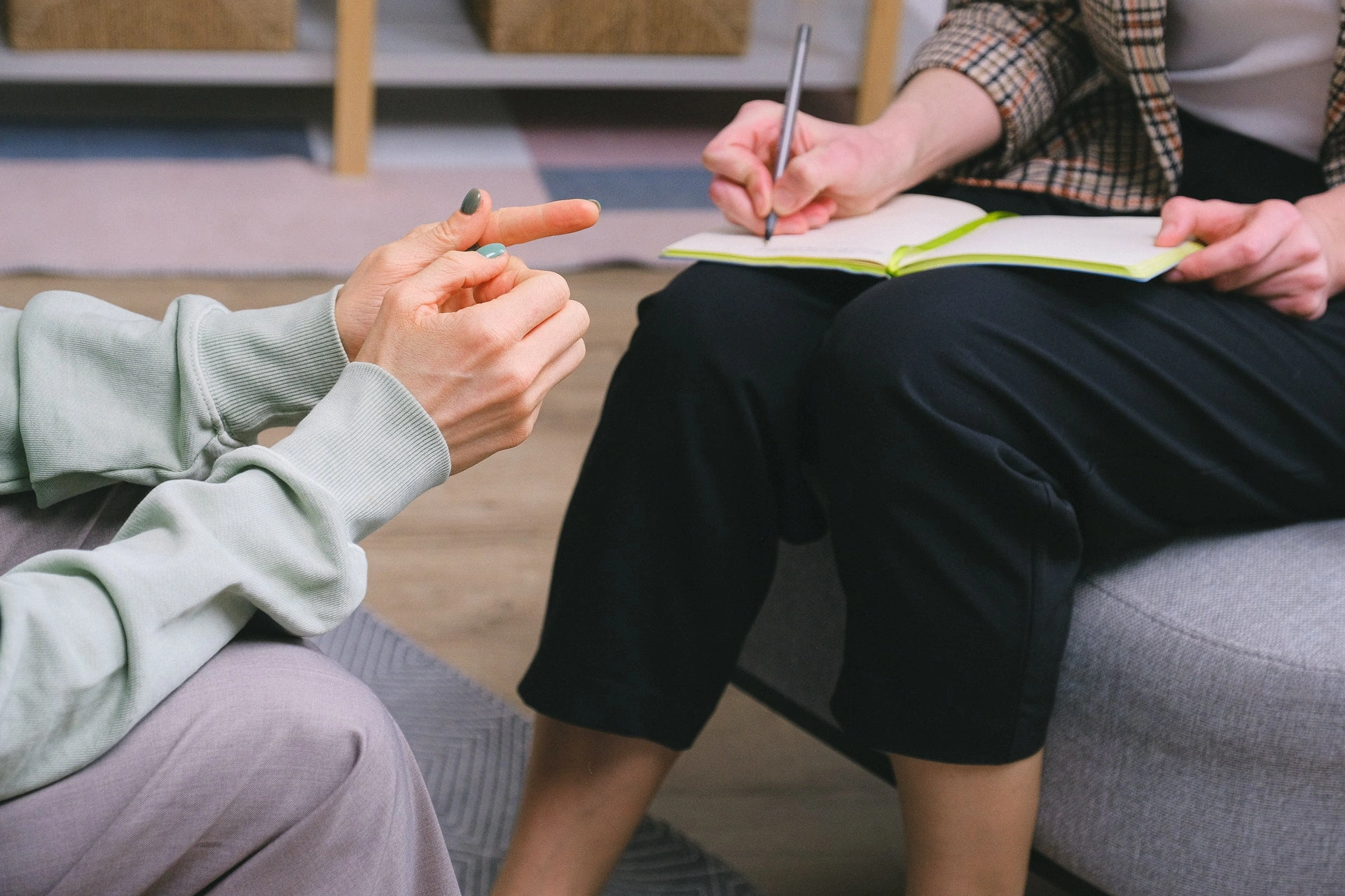 Two people in conversation on sofas during a one-to-one recovery session at Holina Rehab